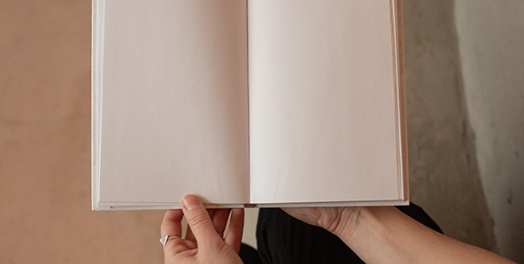 Fotografía de mujer sosteniendo un libro en blanco